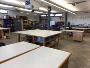 The inside of the workshop with lots of workstations around the room